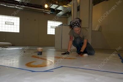 Installing orange octopus surrounded by blue on a polished concrete floor using dye and 3.4 mil vinyl finished with sealer.