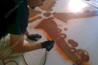 Installation of orange starfish on a polished concrete Floor using dye and 3.4 mil vinyl finished with sealer.