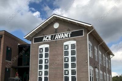 Building with Ace Avant text installed on rough surface building using pounce material and black and white paint