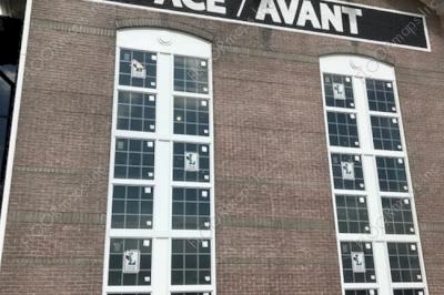 Building with Ace Avant text installed on rough surface building using pounce material and black and white paint.