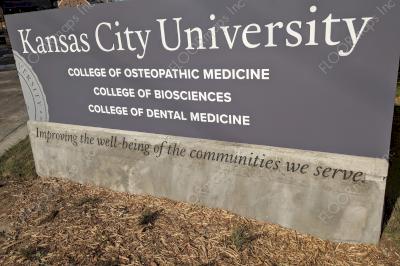 Kansas City University sign with blasted text, Improving the well-being of the communities.