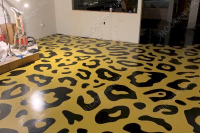 80/20 perforated vinyl print of black and yellow leopard spots on coated concrete floor.