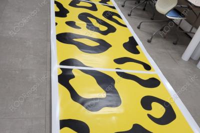 Long line of 80/20 perforated print panels showing the black and yellow leopard design.
